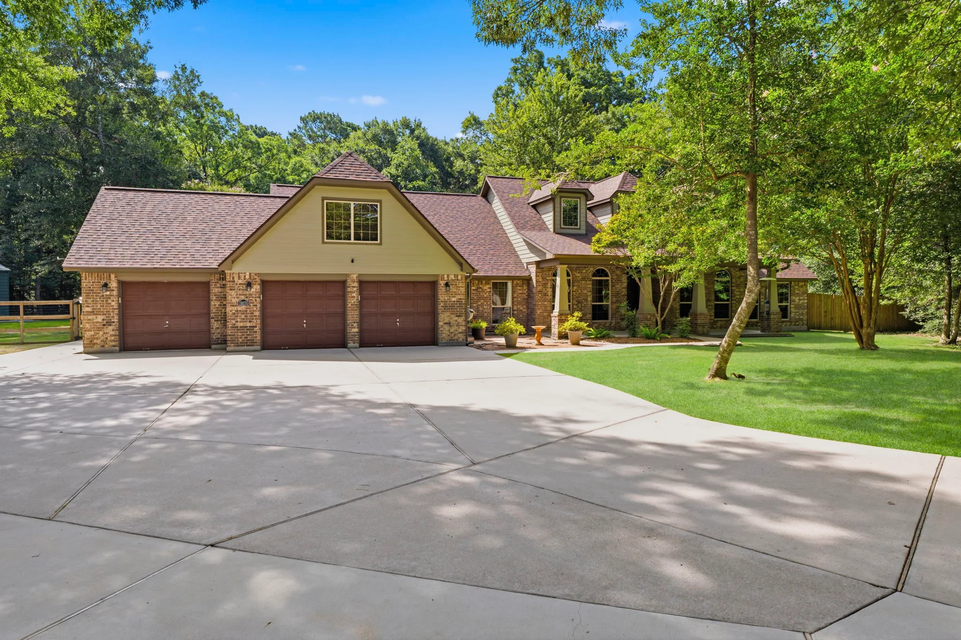 Front facade with dappled tree shadows on driveway and lawn