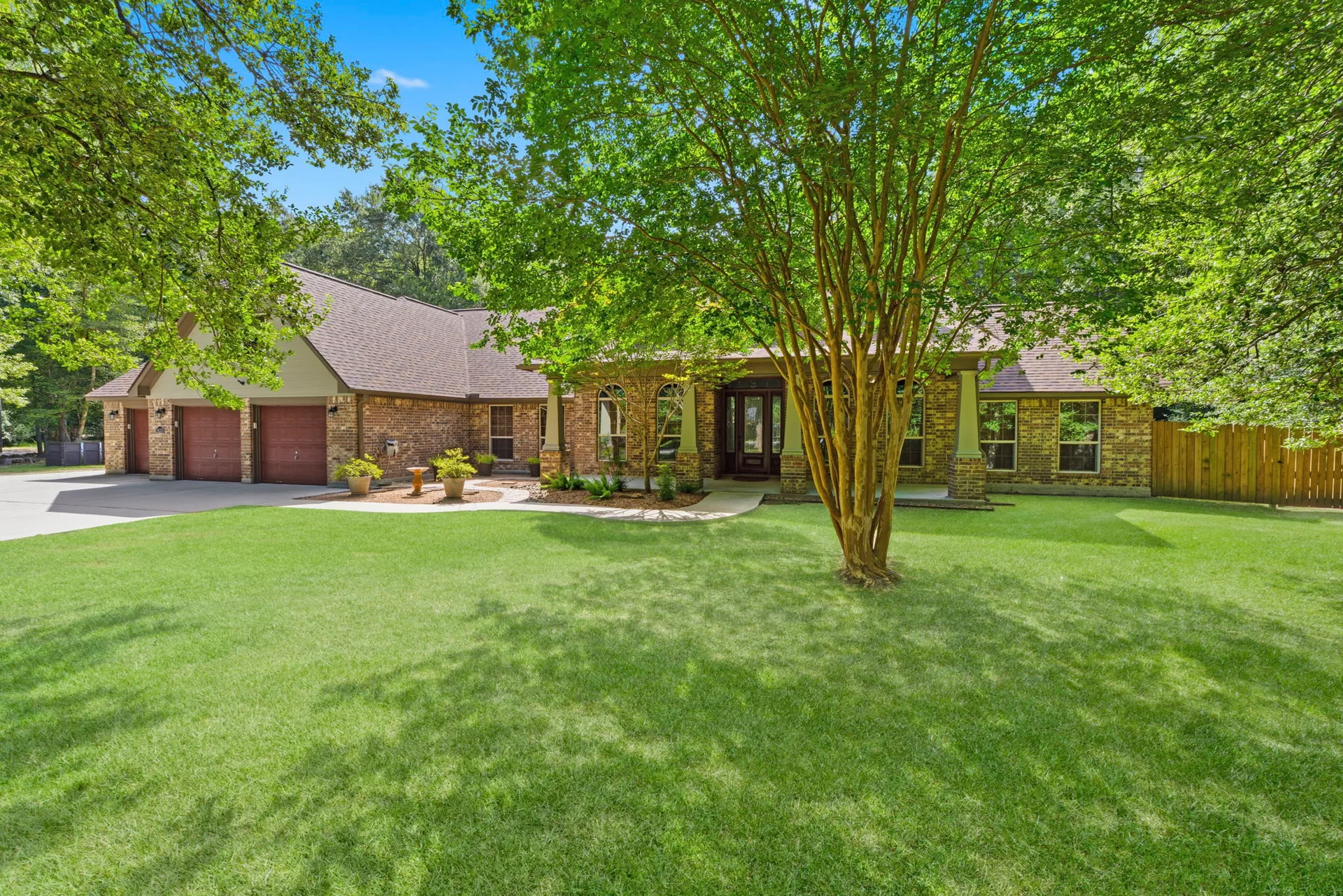 Brick exterior with large lawn and mature tree in center frame