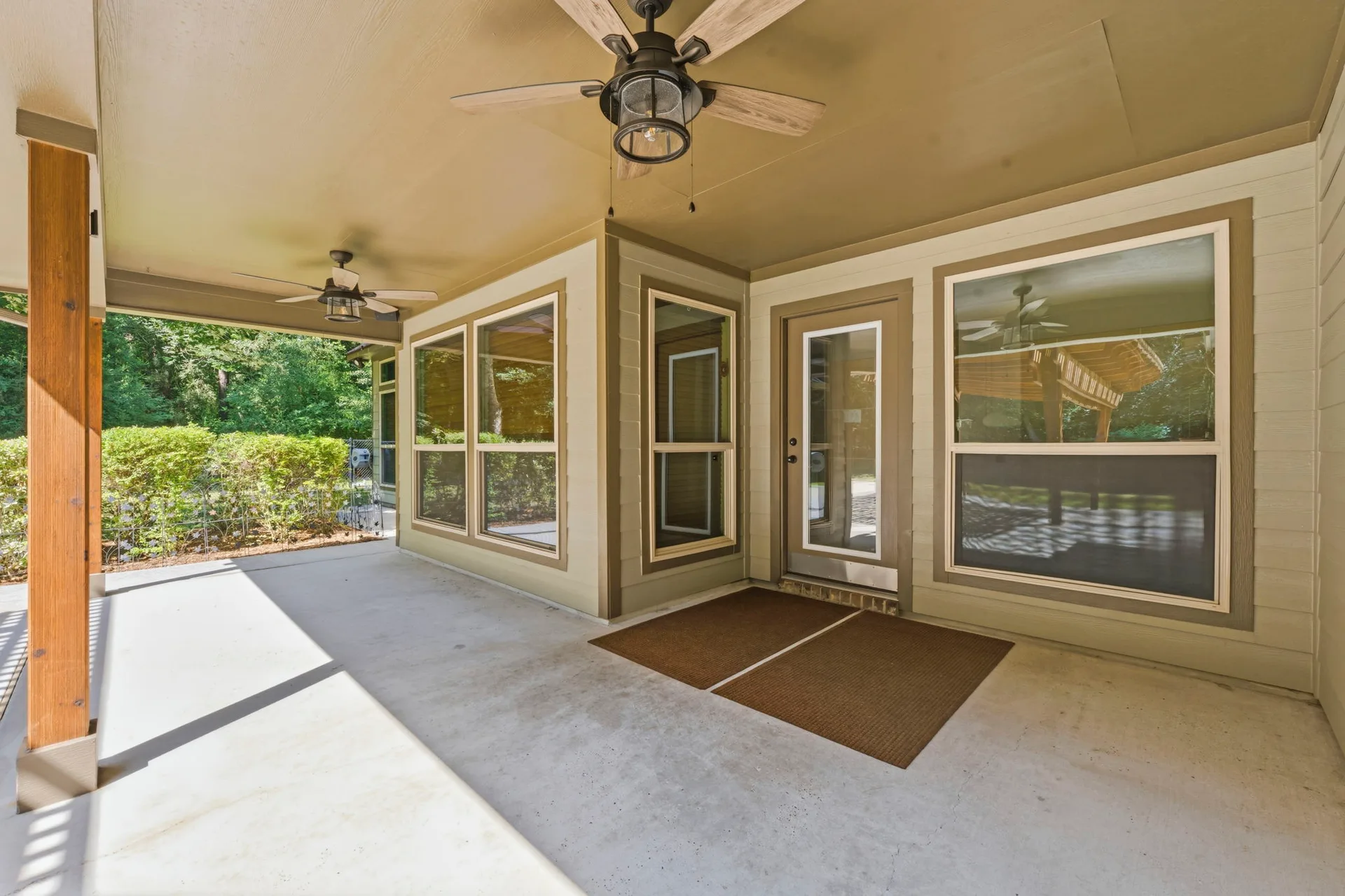 Covered back porch with wood support beams and ceiling fans