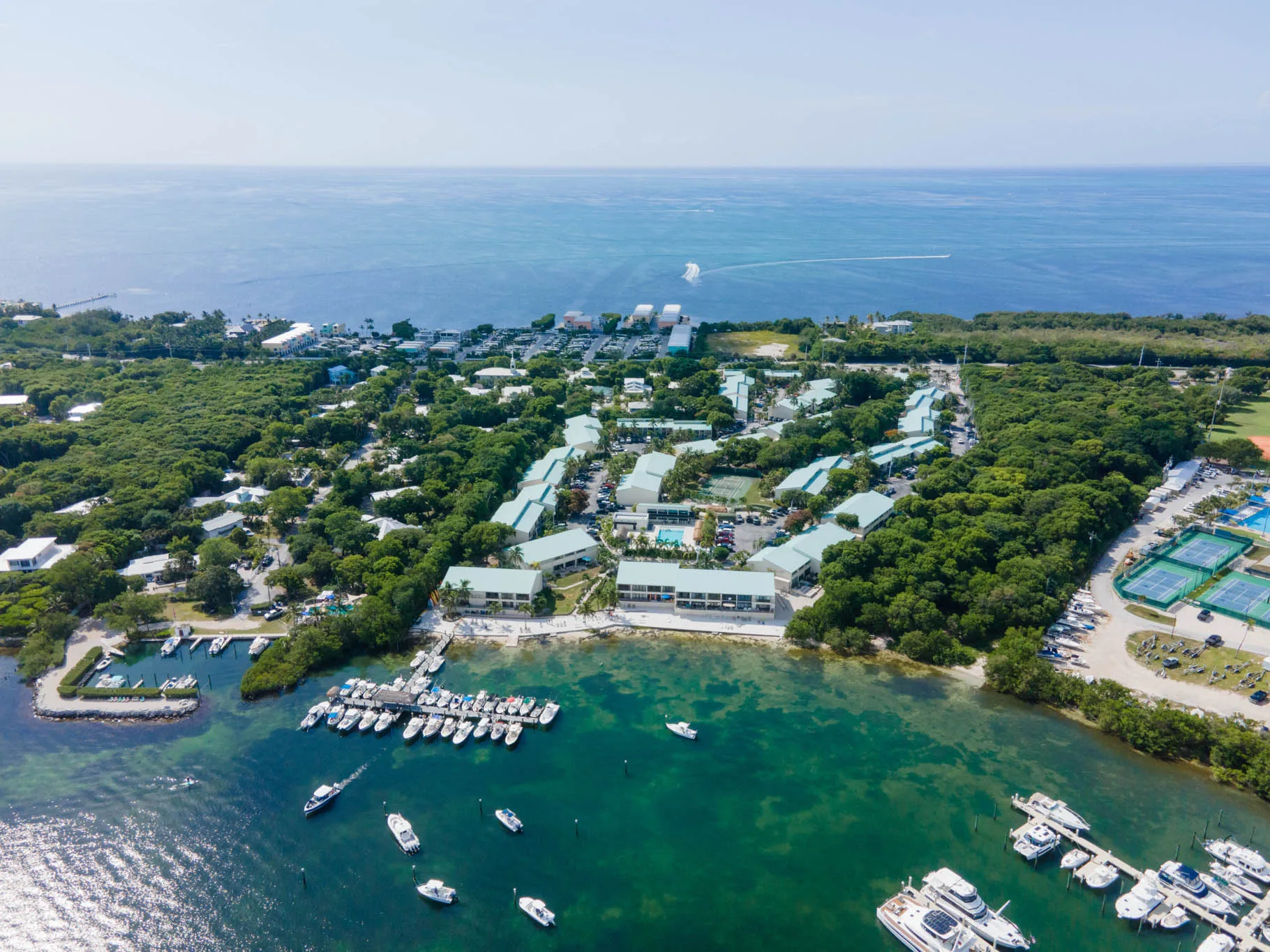 Aerial view of Executive Bay Club, a gated bayfront community in Islamorada with marina, sandy beach, and waterfront townhomes