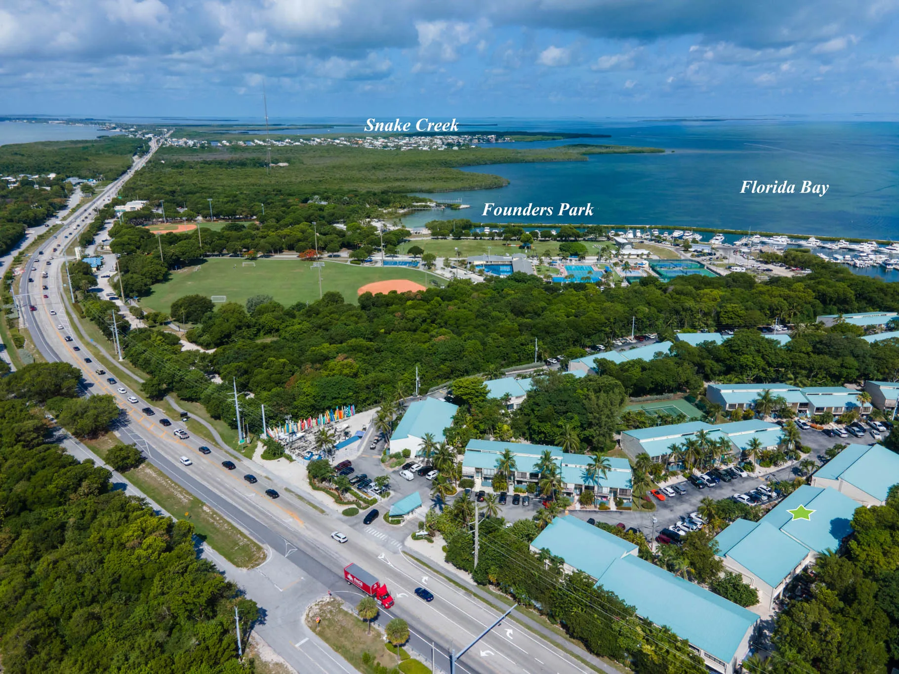 Aerial view of Executive Bay Club community showing surrounding bay, Founders Park, and Snake Creek