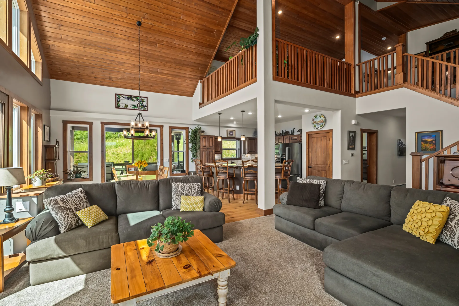 Vaulted living area with wood slat ceilings and open loft overlook