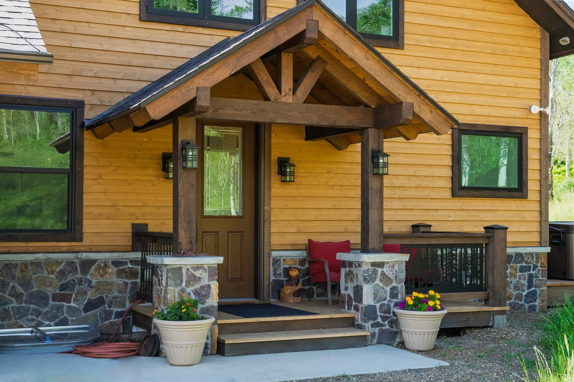 Front entry porch with cedar siding and timber-framed roof