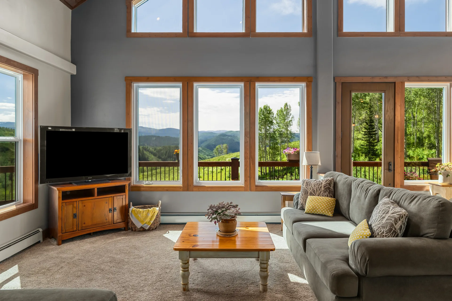 Wide living room with tall vaulted ceilings and expansive windows