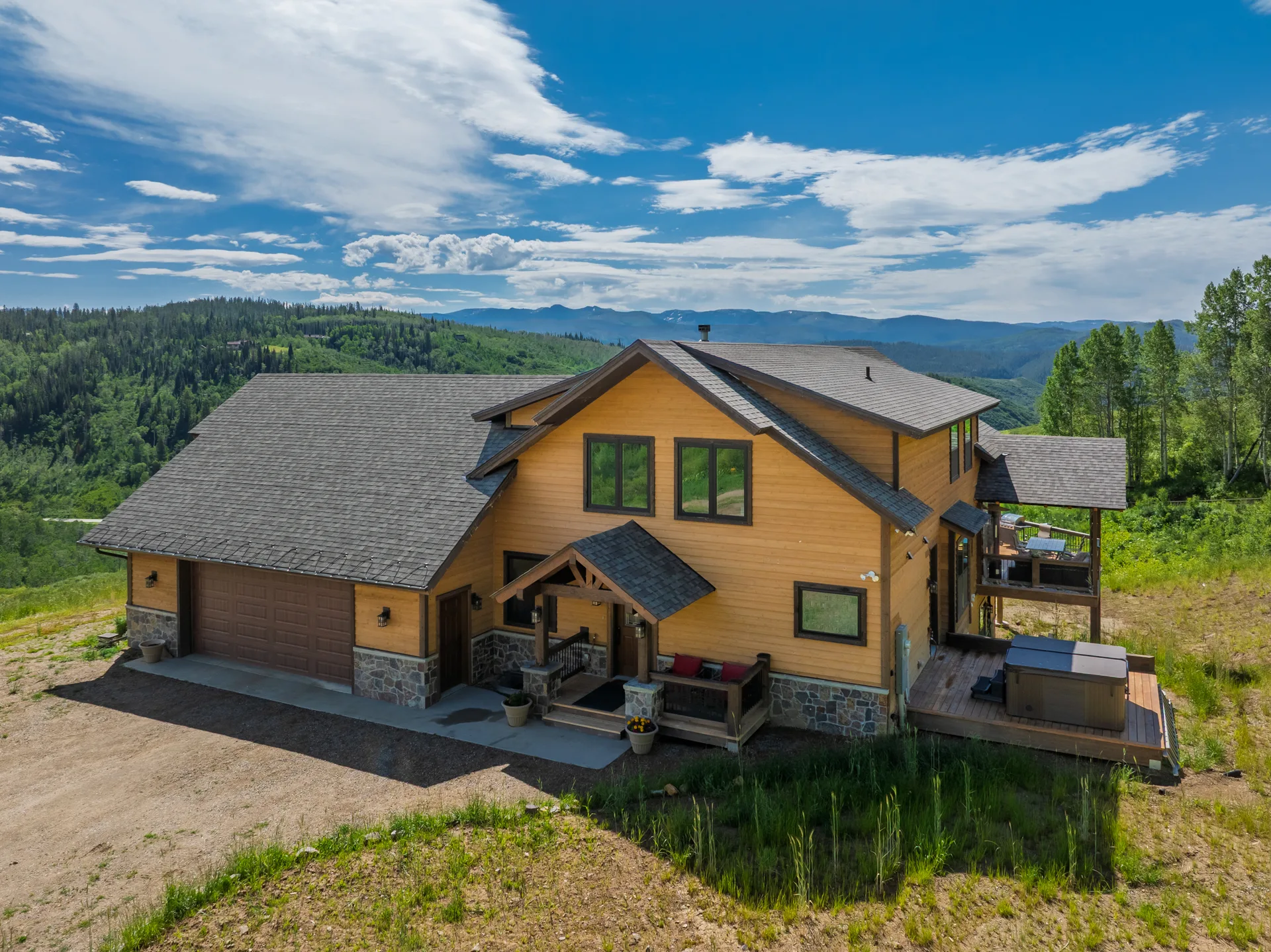 Side facade of mountain home with hot tub and deck