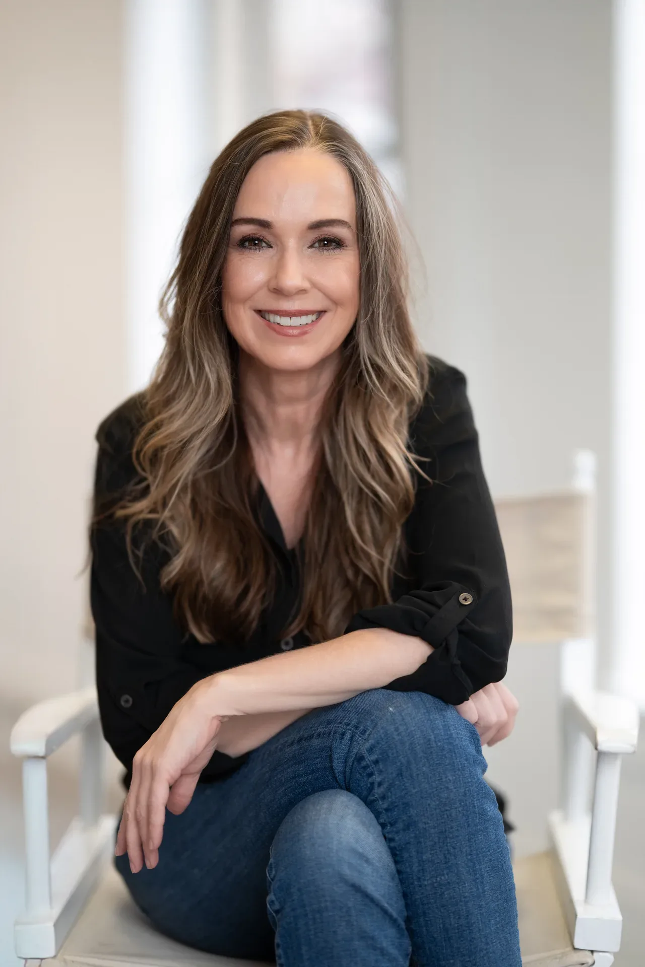 Dawn Cordiner sitting in a white director chair, relaxed and approachable