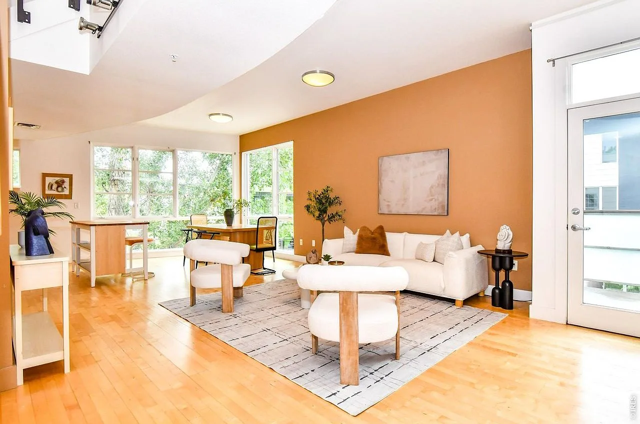 Open-concept loft living area with dramatic high ceilings, hardwood floors, and natural light