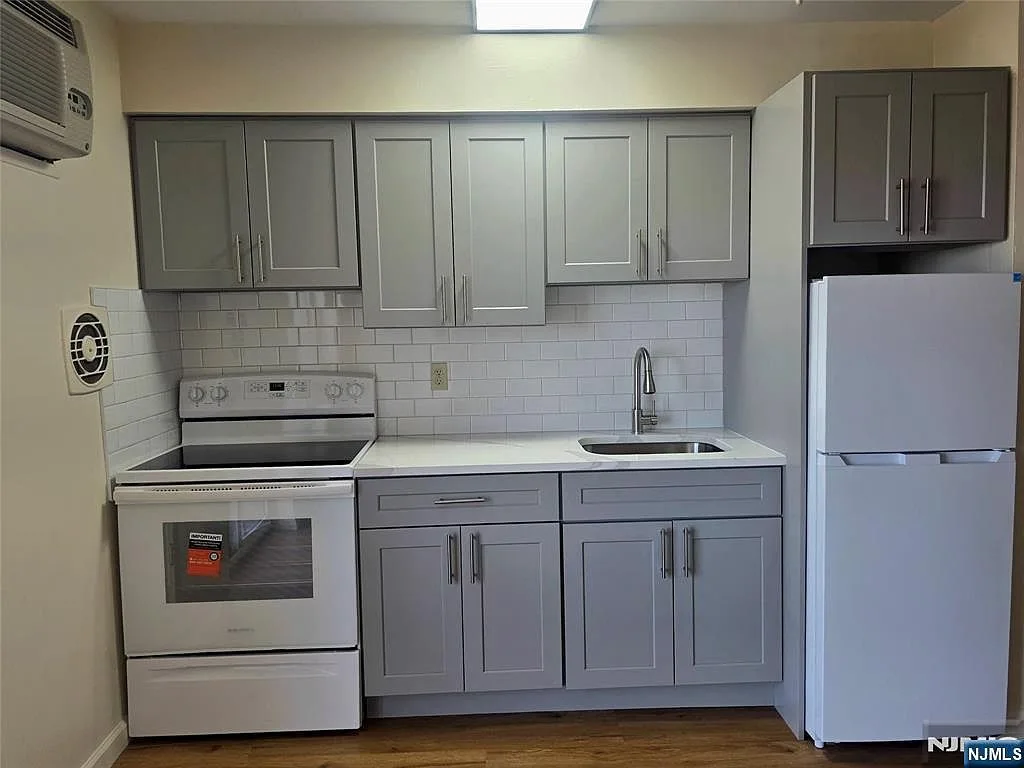 Renovated kitchen with grey shaker cabinets and new countertops