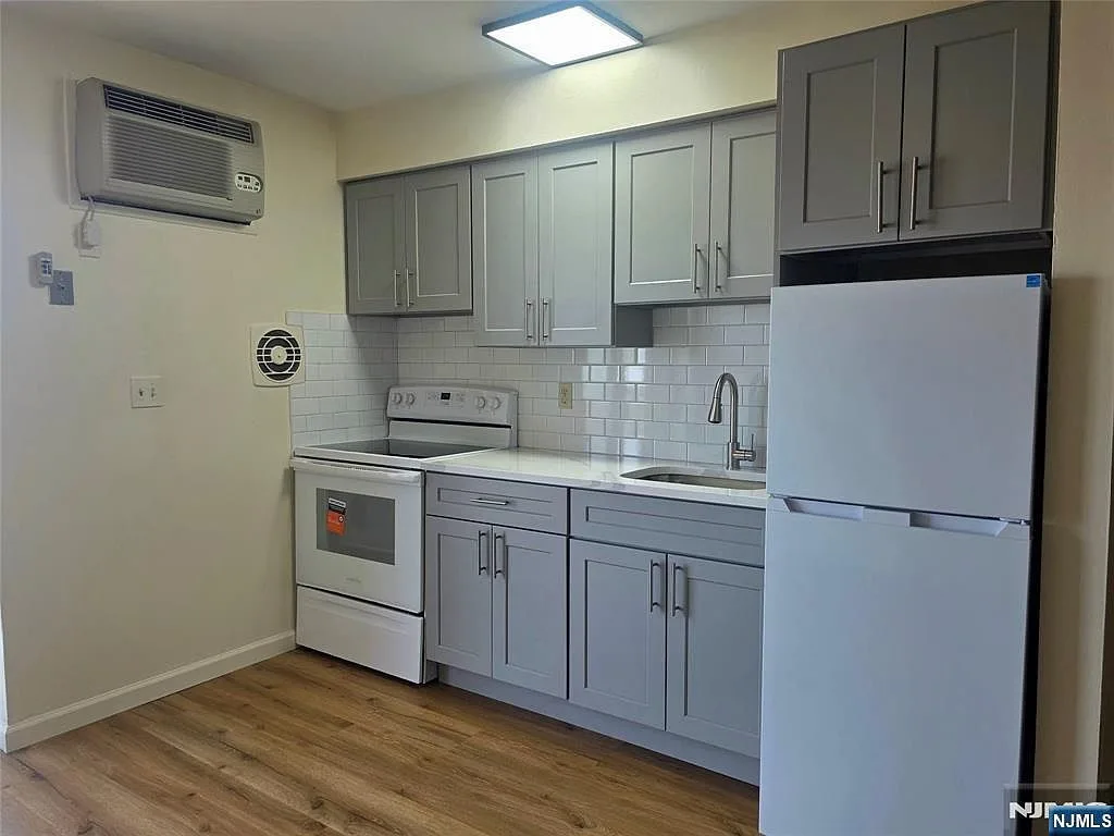 Wide-angle view of renovated kitchen with new appliances