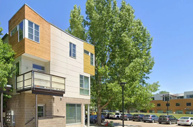 Exterior facade of Boho Lofts, a contemporary townhouse building with wood siding and stone accents in Prospect neighborhood, Longmont