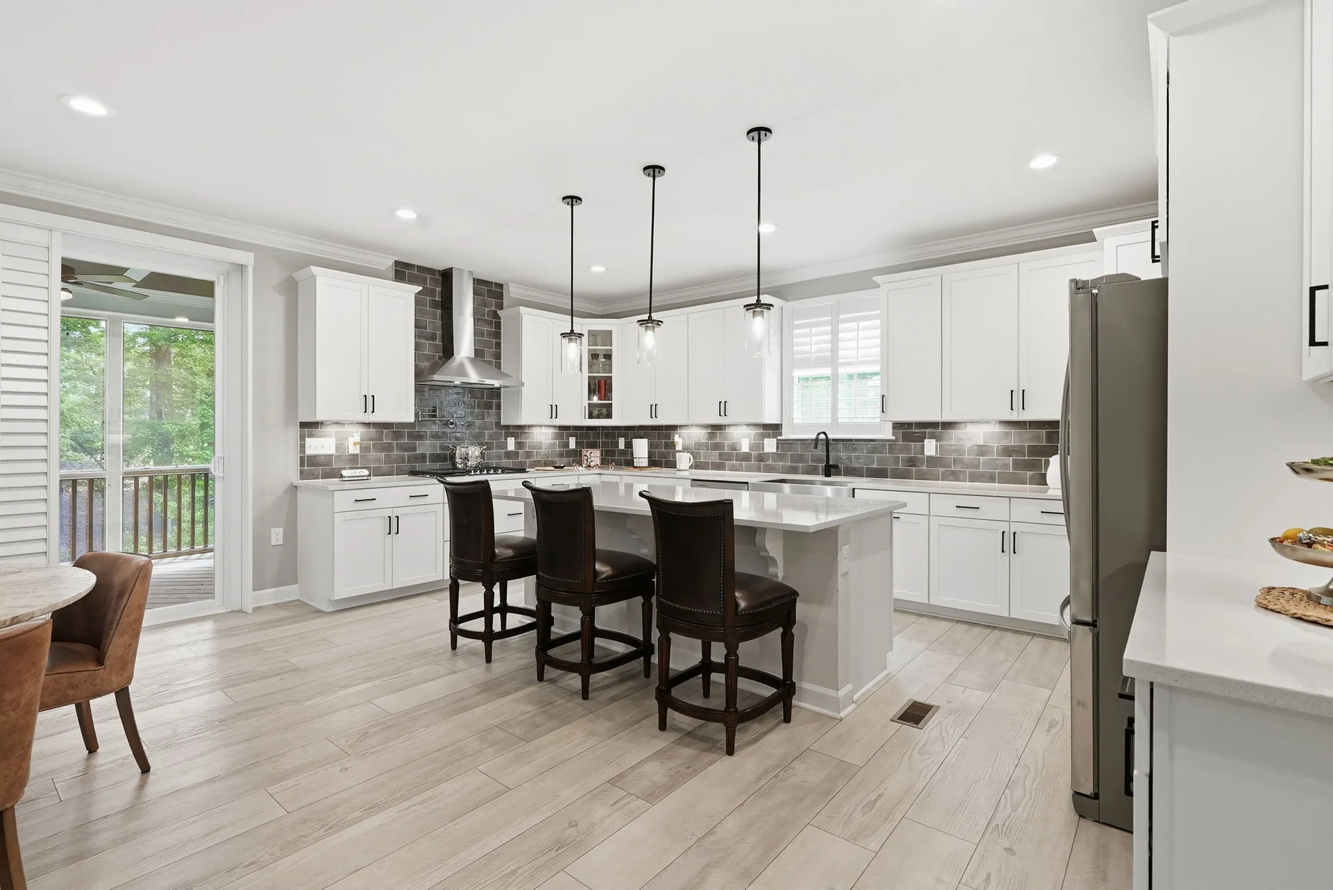 Open-concept chef's kitchen at 297 Bonaventure Dr with white shaker cabinets, oversized island, and quartz countertops