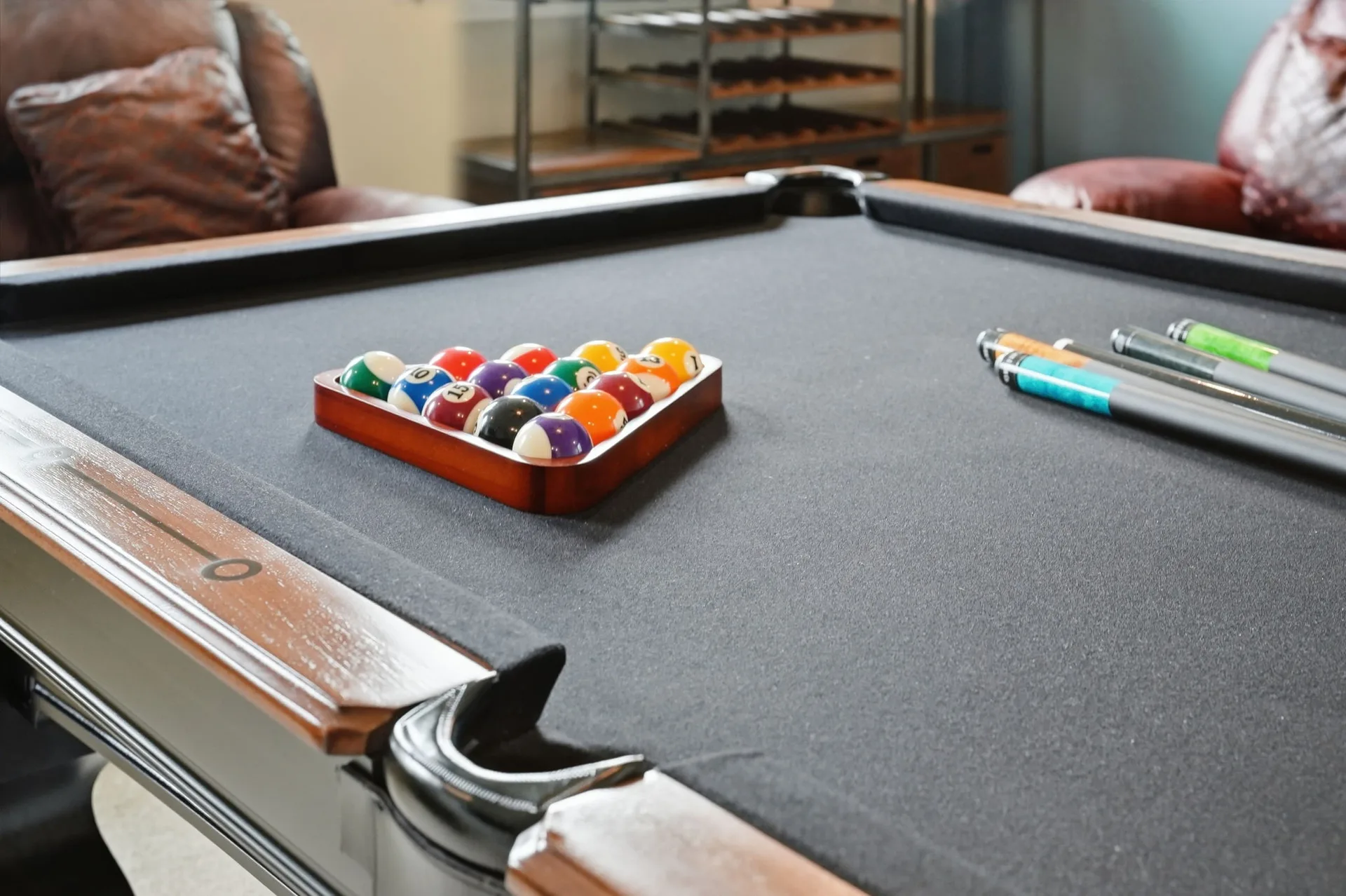 Upstairs loft game room with pool table, billiard balls, and leather lounge chairs