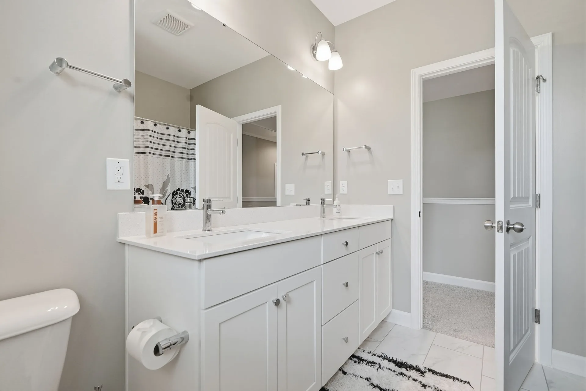 Bathroom with white shaker vanity, quartz countertop, and neutral gray-beige paint