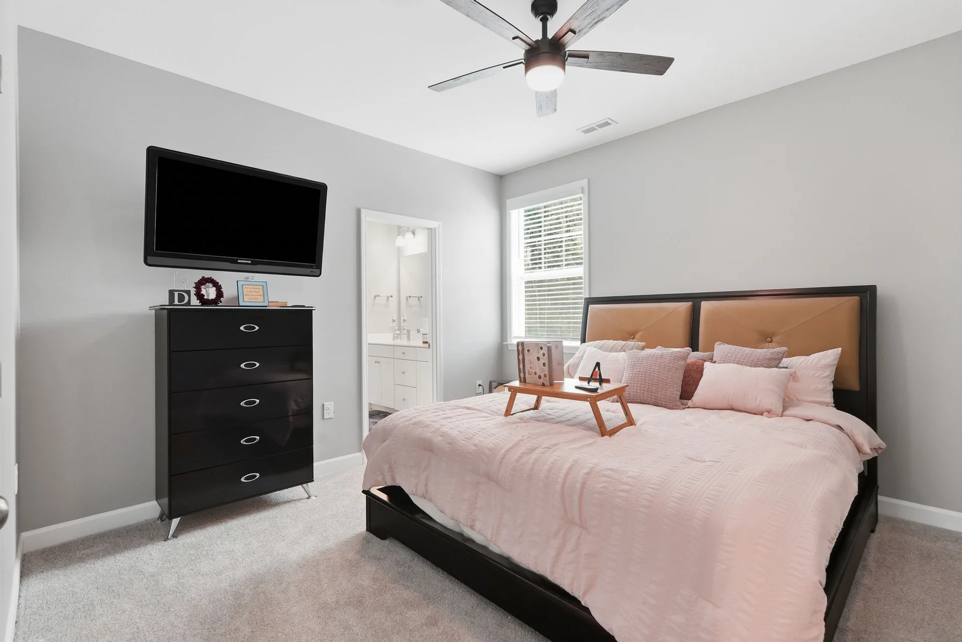 Bedroom with ensuite access featuring grey walls, white trim, and king-sized bed