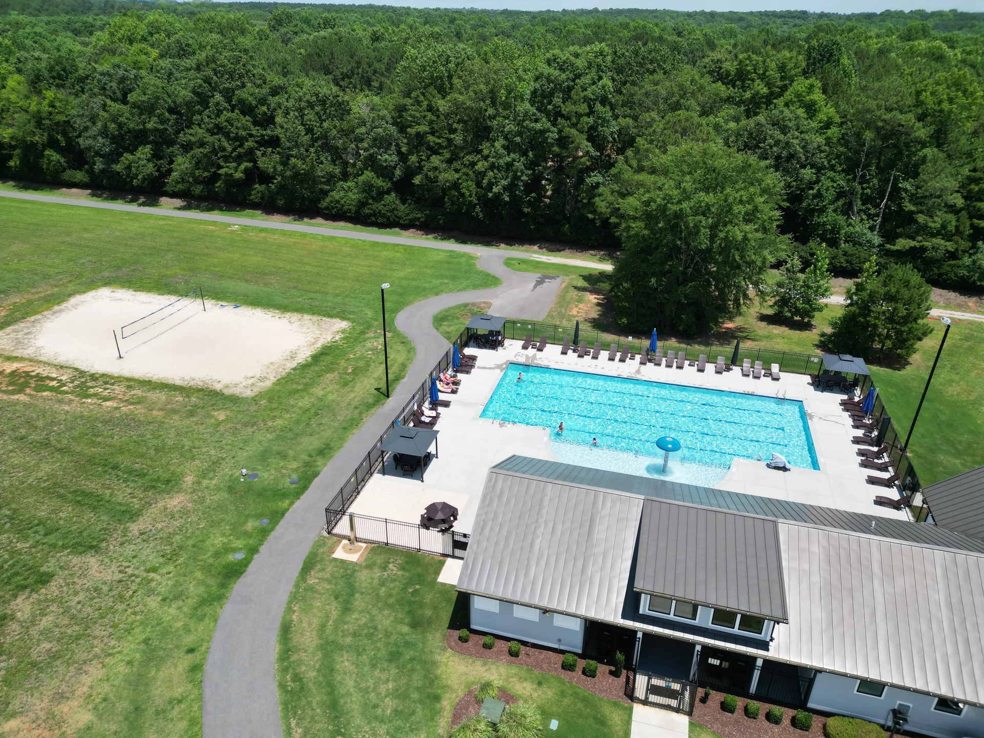 Aerial view of the Portofino community pool with resort-style clubhouse and sand volleyball court