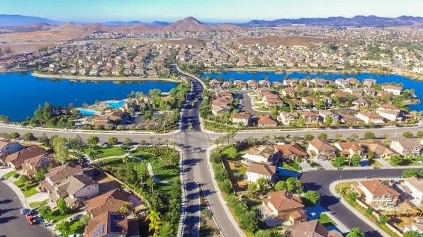 Aerial drone view of Menifee residential community with houses surrounding a lake