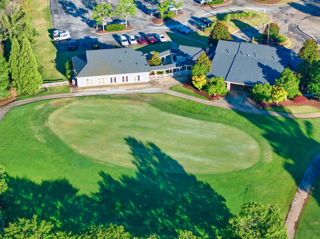 High-altitude drone shot of clubhouse and golf green