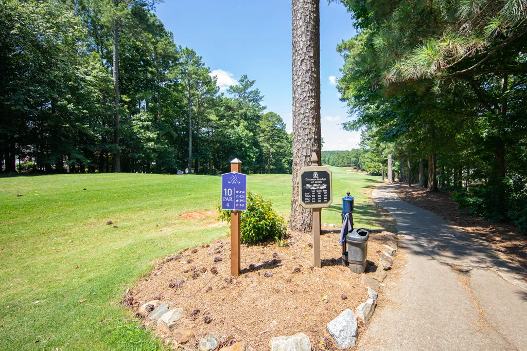 View of golf course hole with fairway and cart path