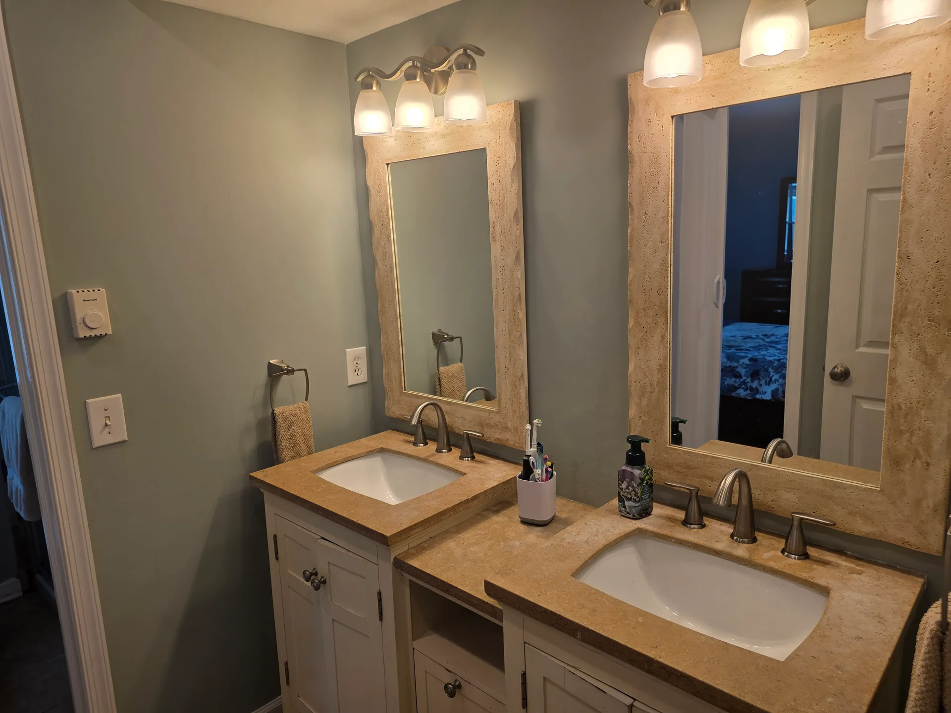 Remodeled bathroom with double sink vanity and stone countertops