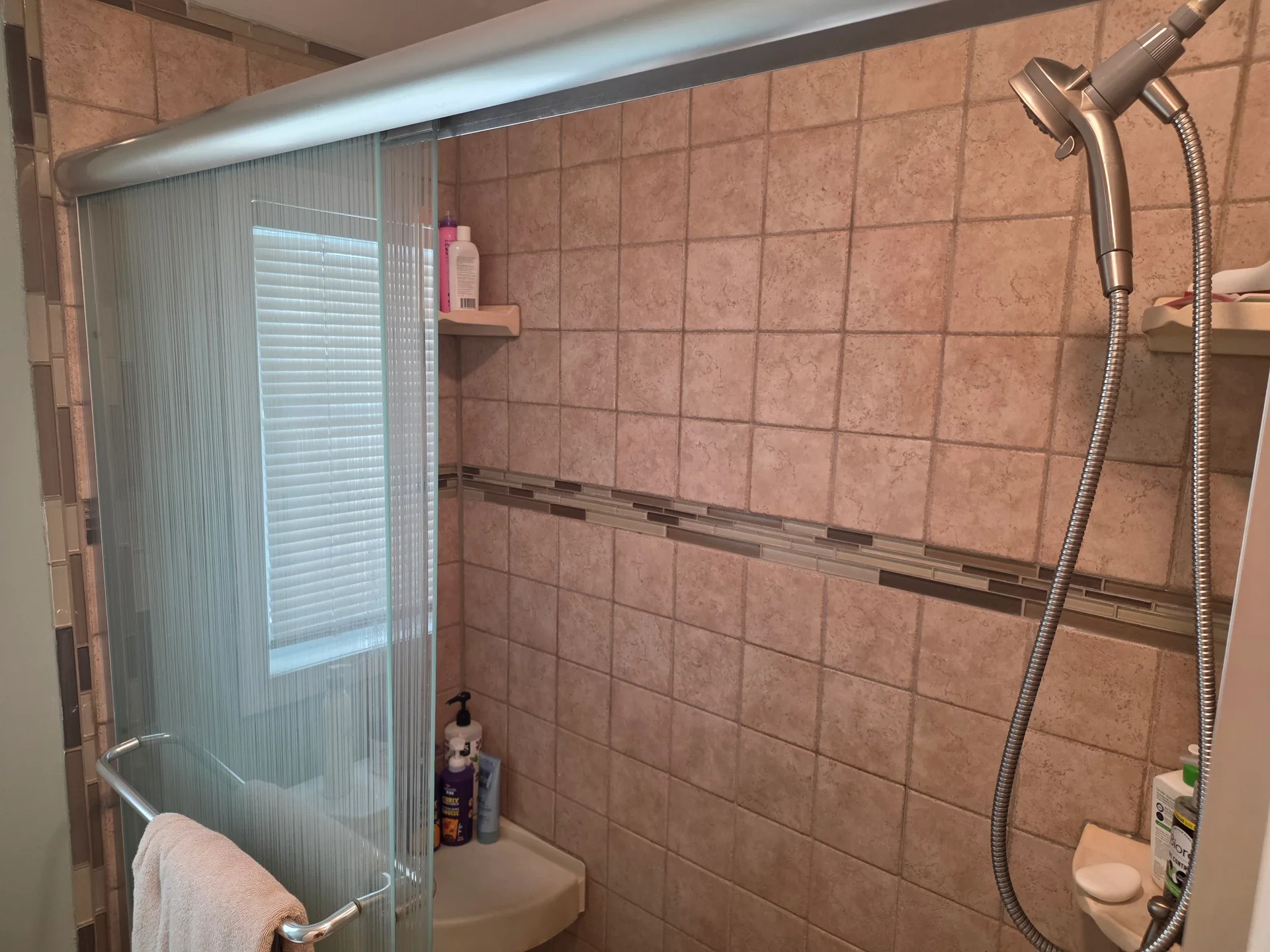 Walk-in shower with earth-tone ceramic tiles
