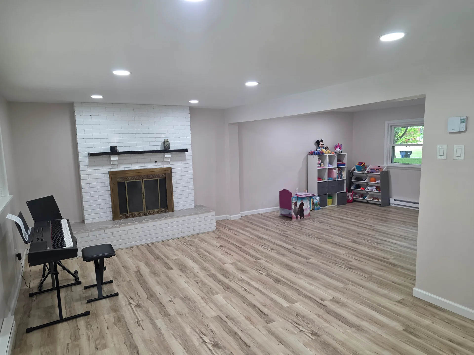 Lower level family room with recessed lighting and vinyl plank flooring