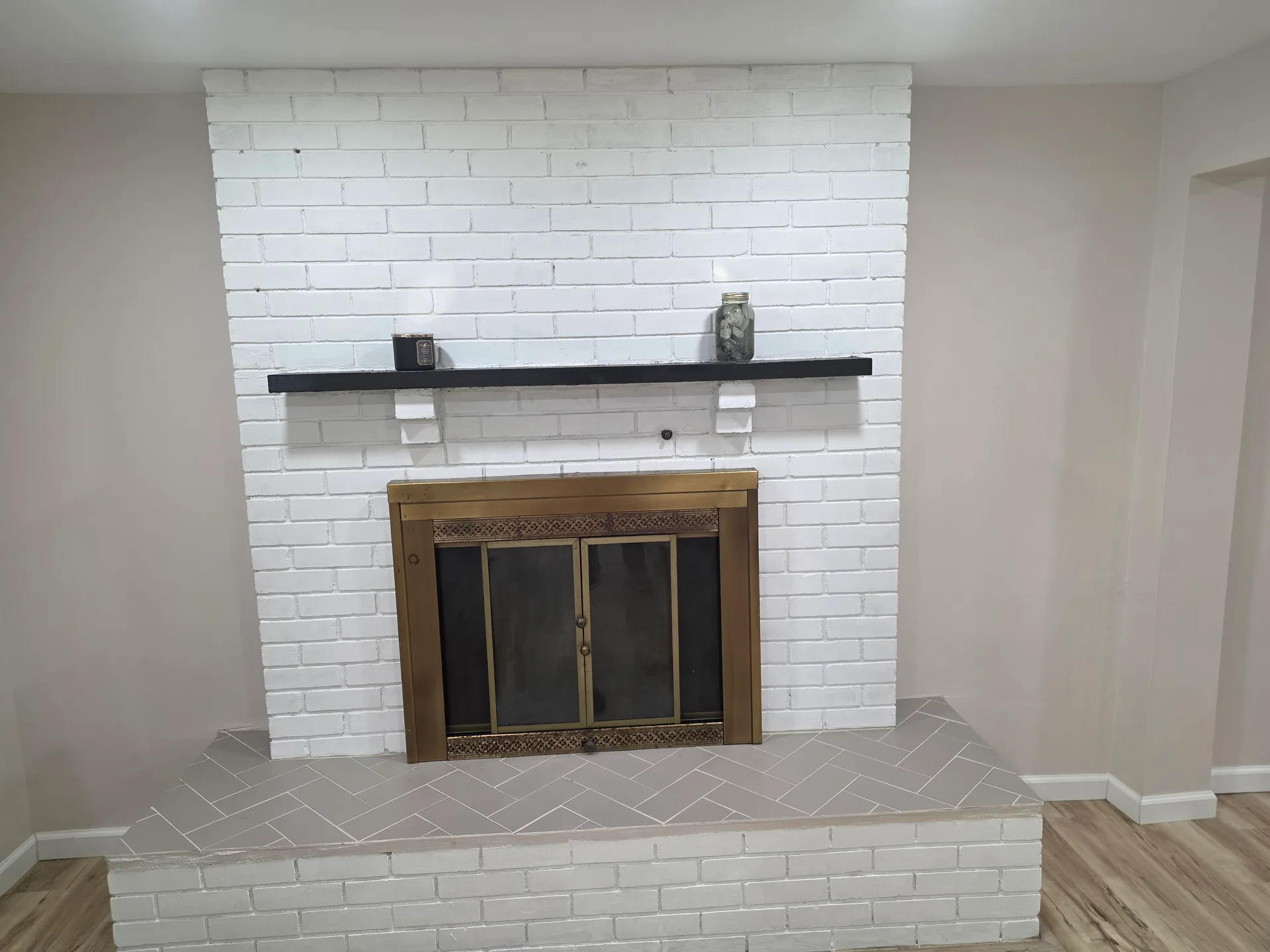 White painted brick fireplace with black mantel