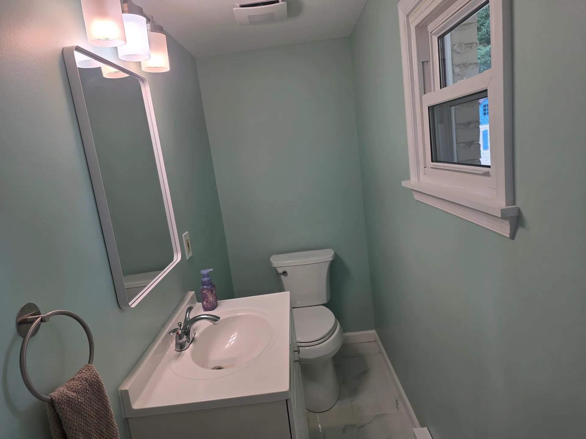 Powder room with soft blue walls and white vanity