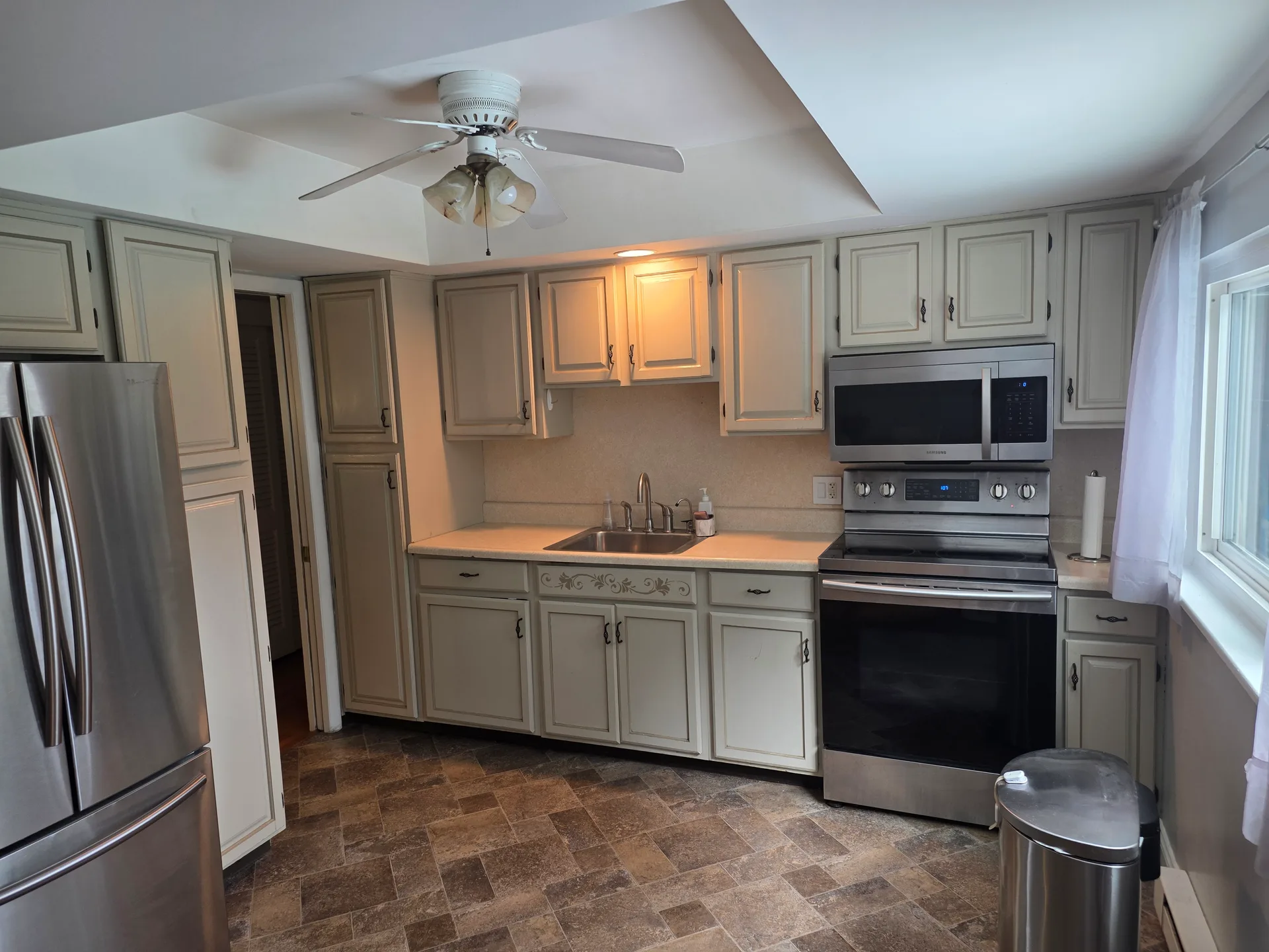 Kitchen with beige shaker cabinetry and stainless steel appliances