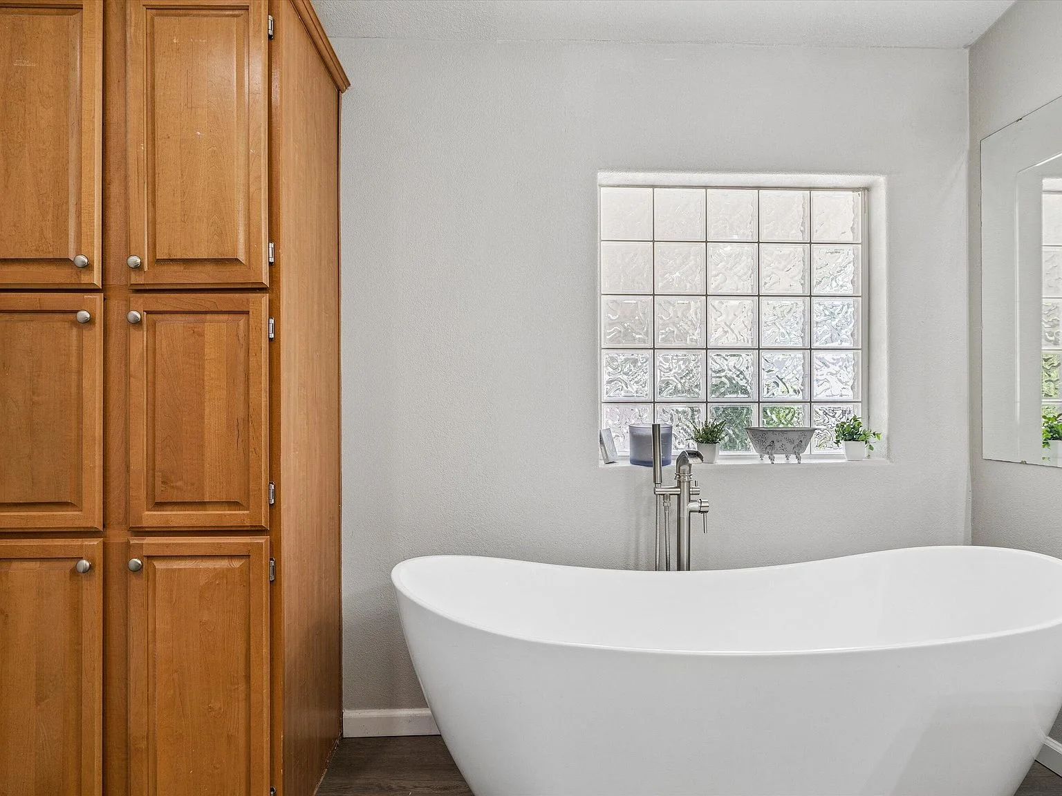 Bathroom with white soaking tub and glass-block window
