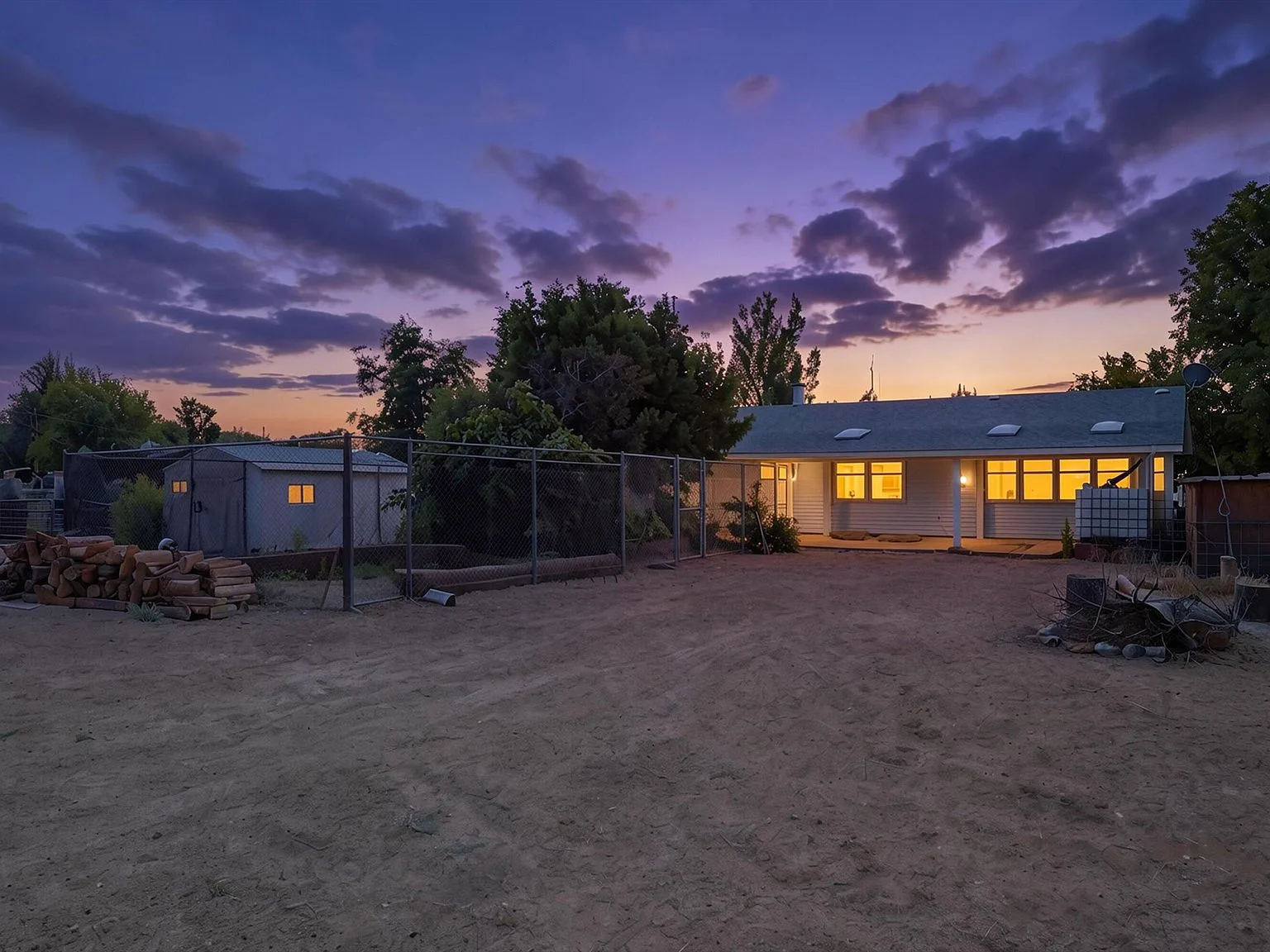 Backyard twilight view with warm window light