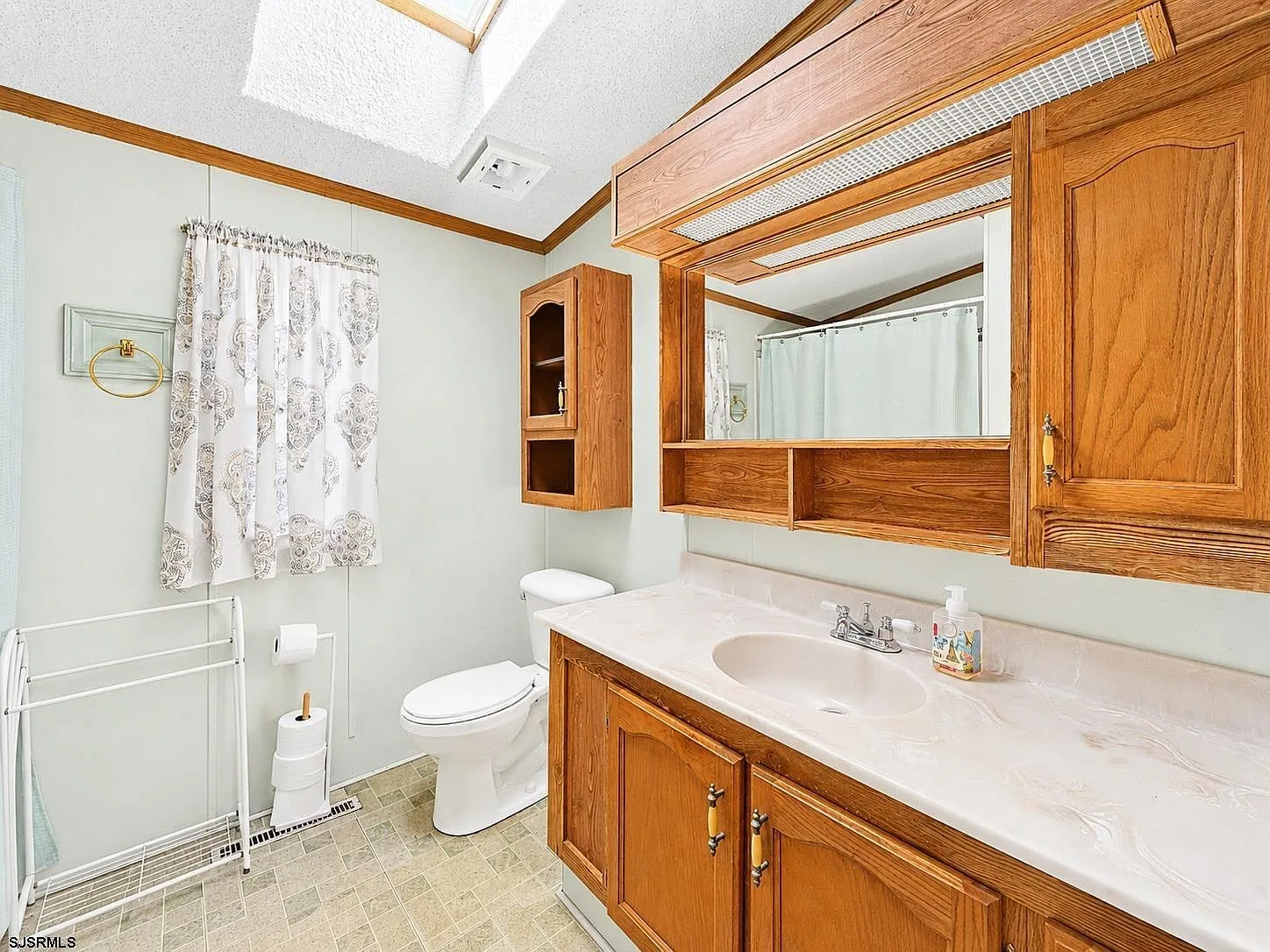 Bathroom with oak vanity and skylight