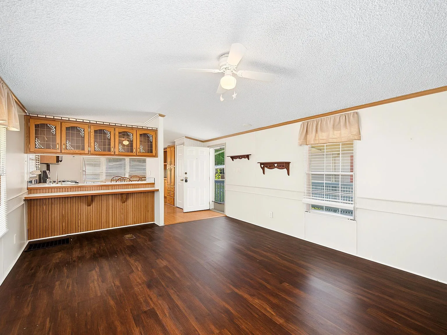 Spacious living room looking into the kitchen with high ceilings and natural light