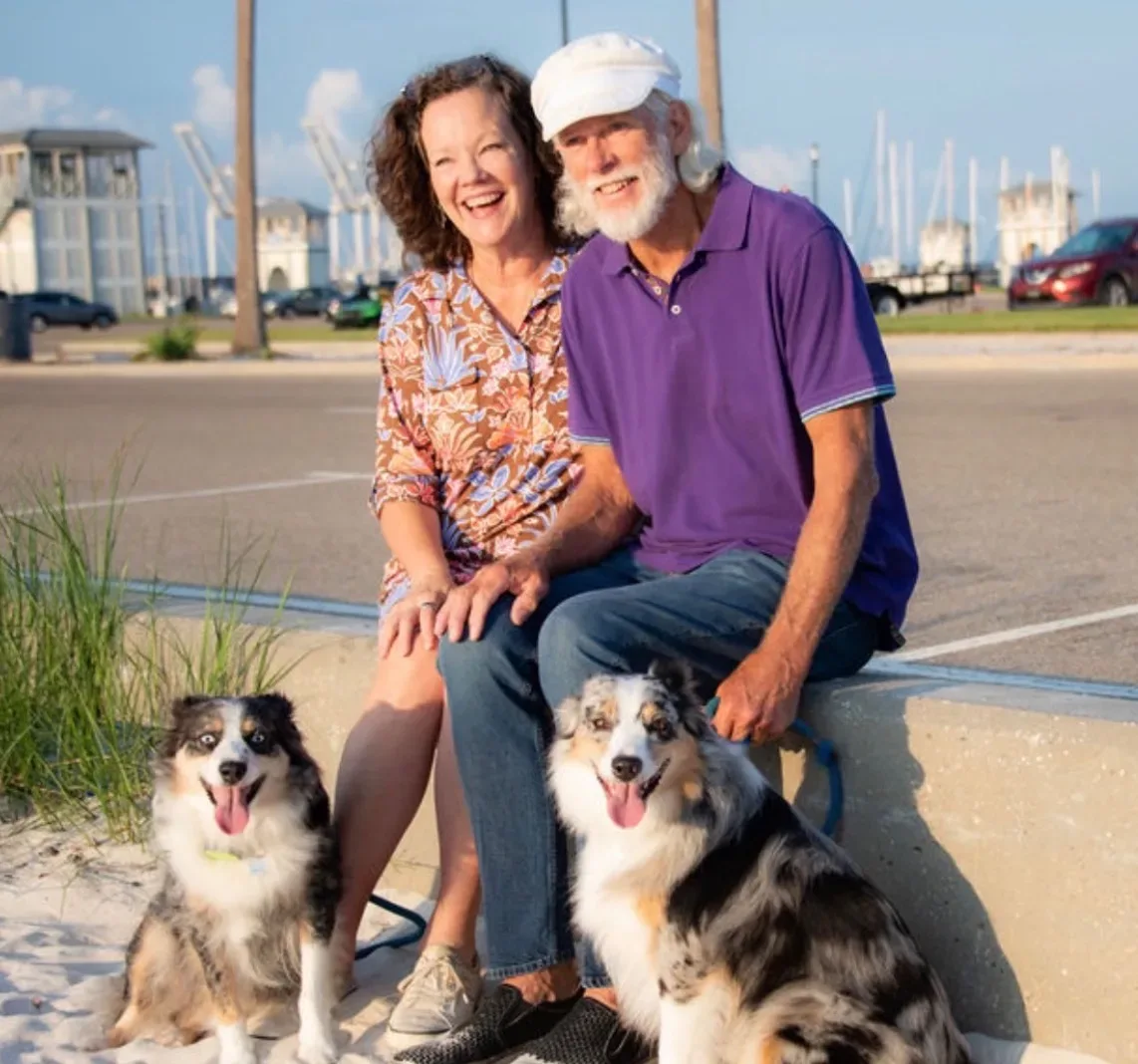 Judy Atherton, her husband Lance, and their Mini Aussies Brizzie and Ash at the sea wall in Gulfport