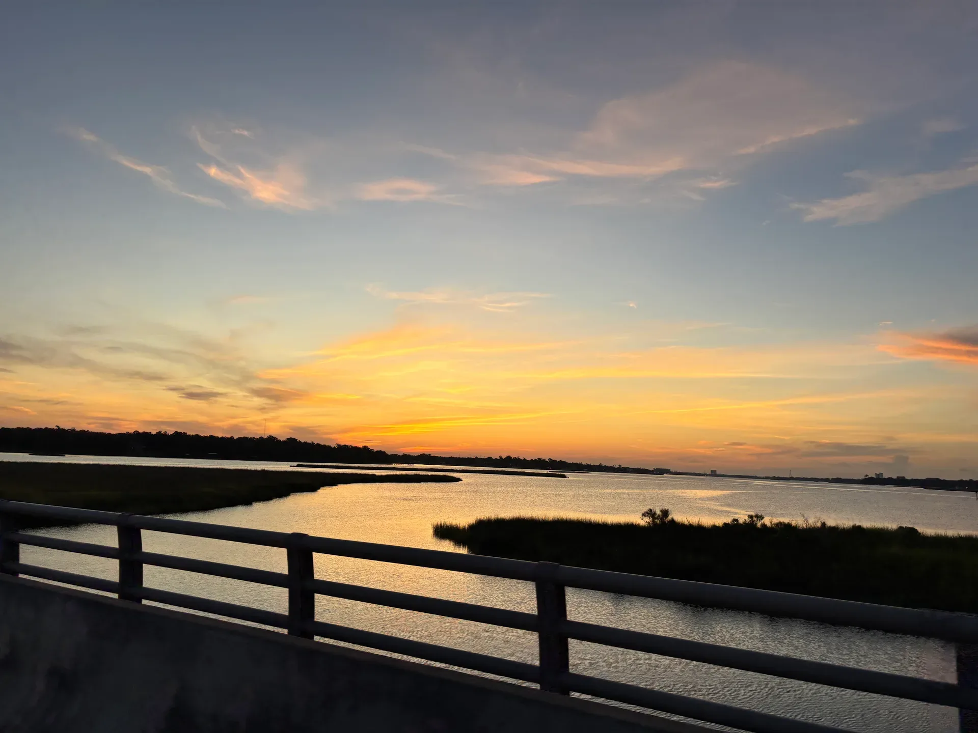 Scenic sunset over waterway with marshland