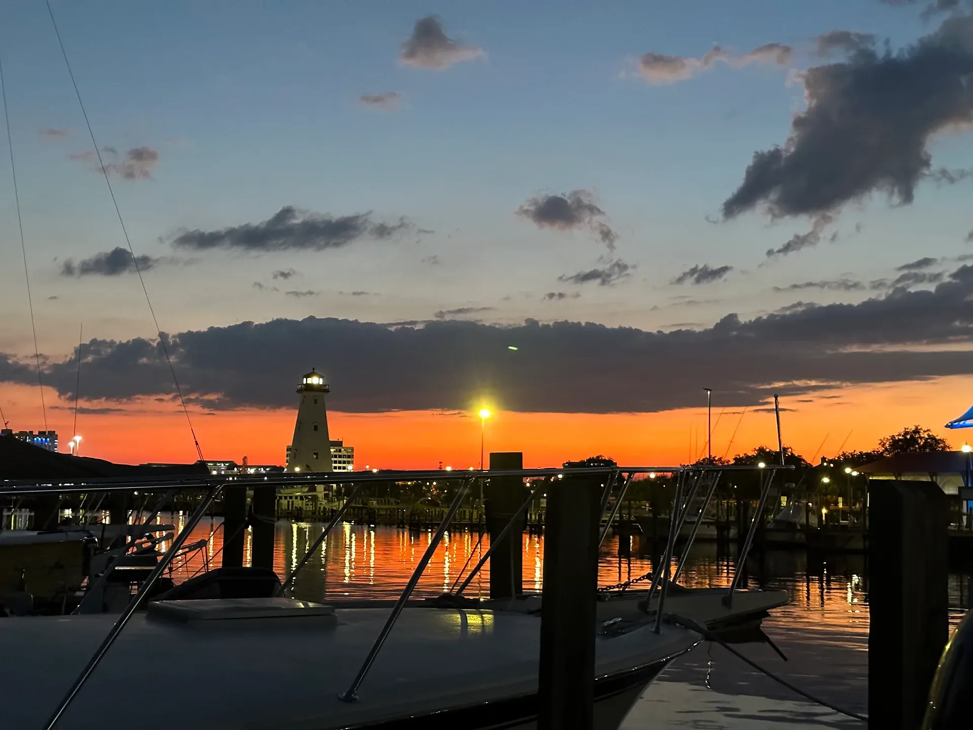 Twilight view of a glowing lighthouse over a harbor