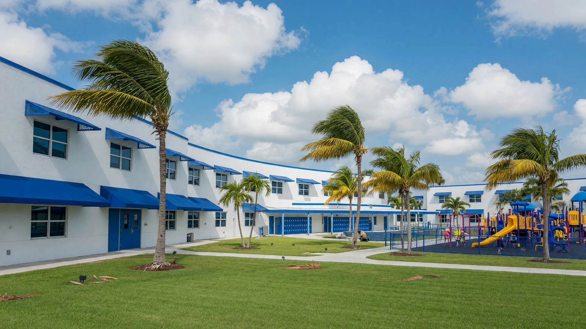 School campus in South Florida with modern buildings, palm trees, and blue sky