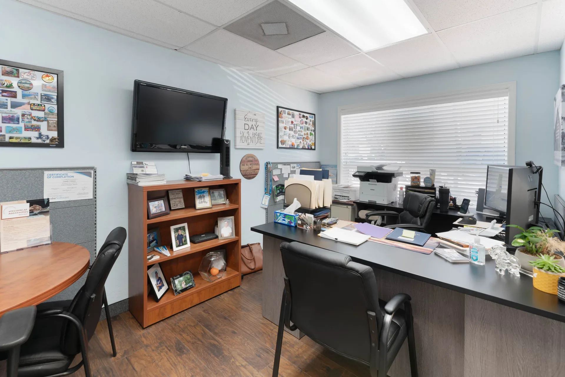 Small commercial office workspace with drop ceiling and wood-look vinyl flooring