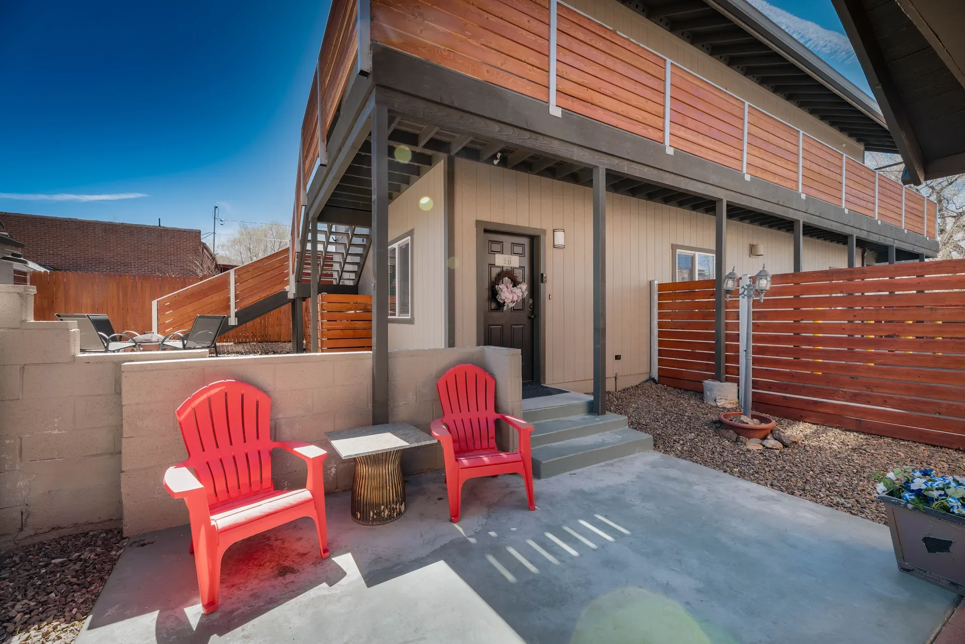 Private courtyard with modern wood slats, steel framing, and concrete finish