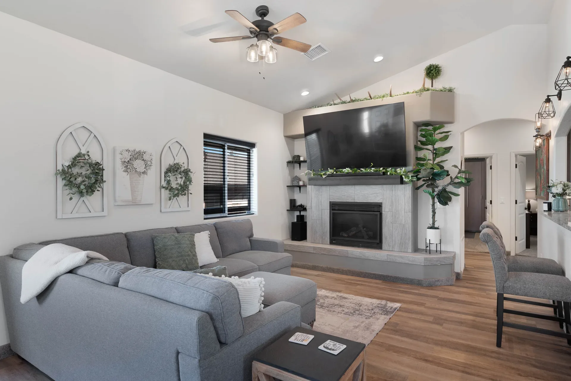 Living room with vaulted ceilings, floor-to-ceiling fireplace, and wood laminate flooring