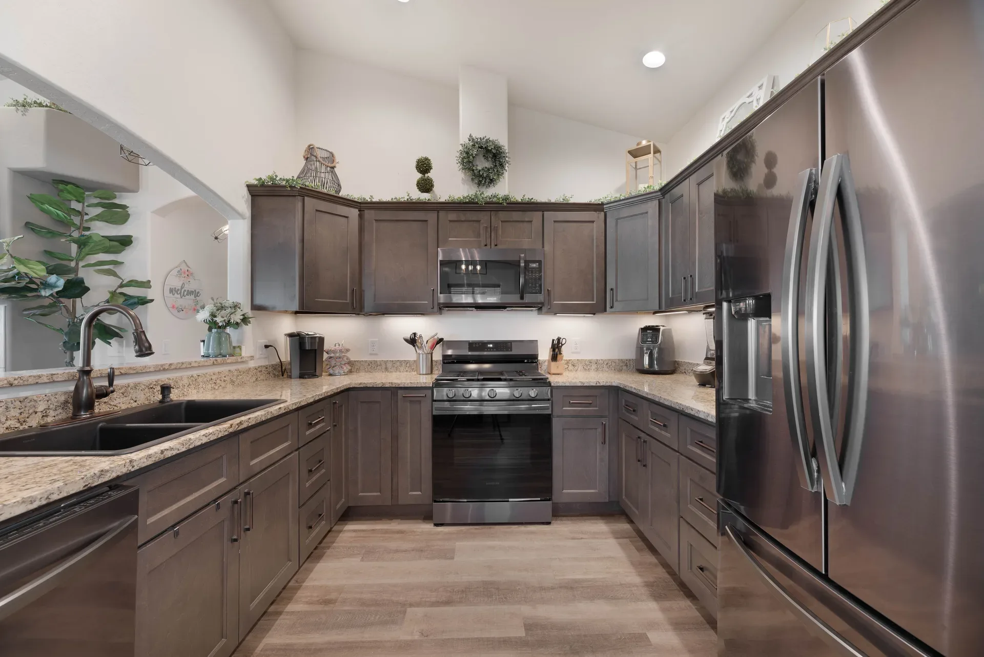 Renovated kitchen with dark wood cabinets, granite countertops, and stainless steel appliances