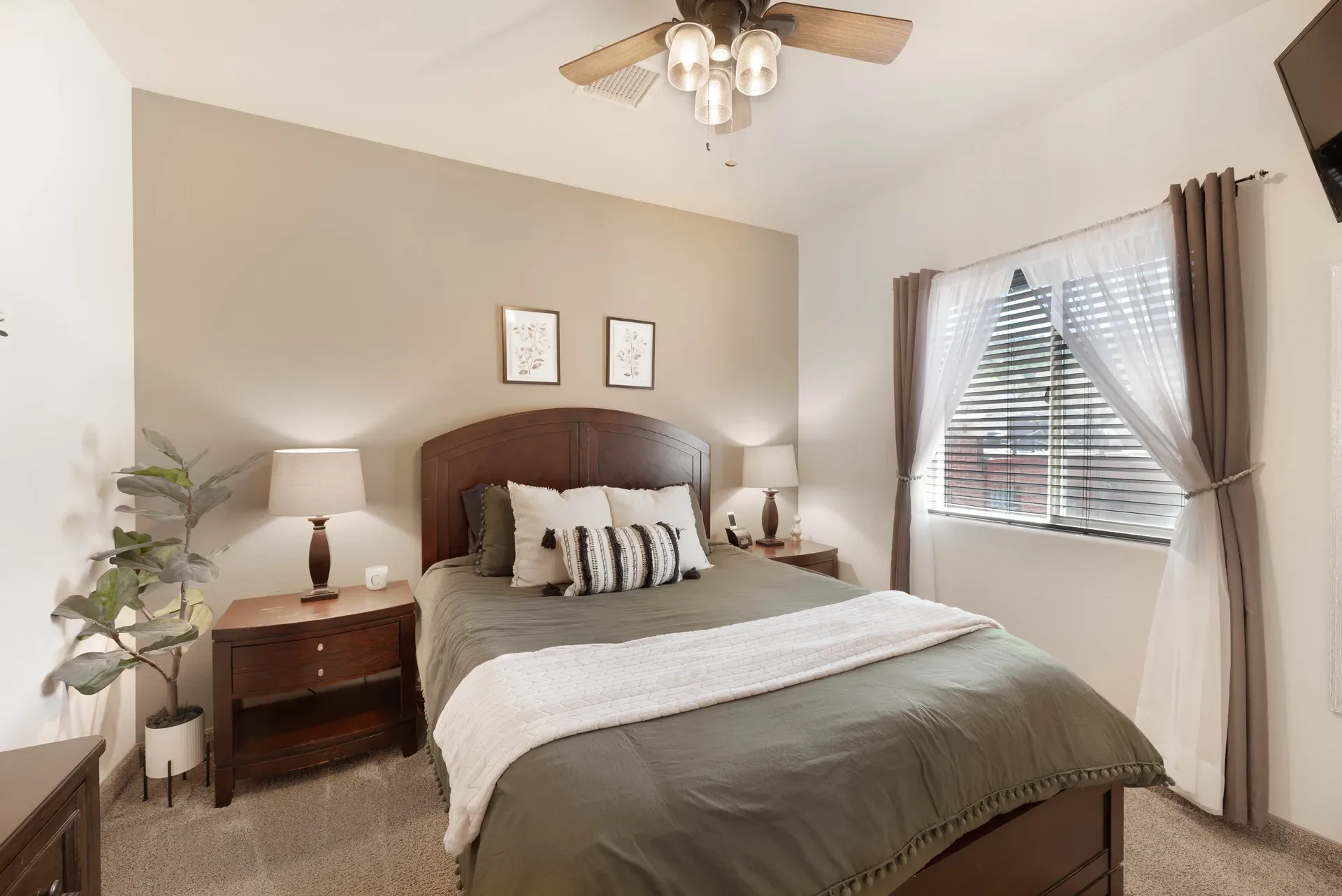 Furnished bedroom with beige walls, dark wood furniture, and carpeted flooring
