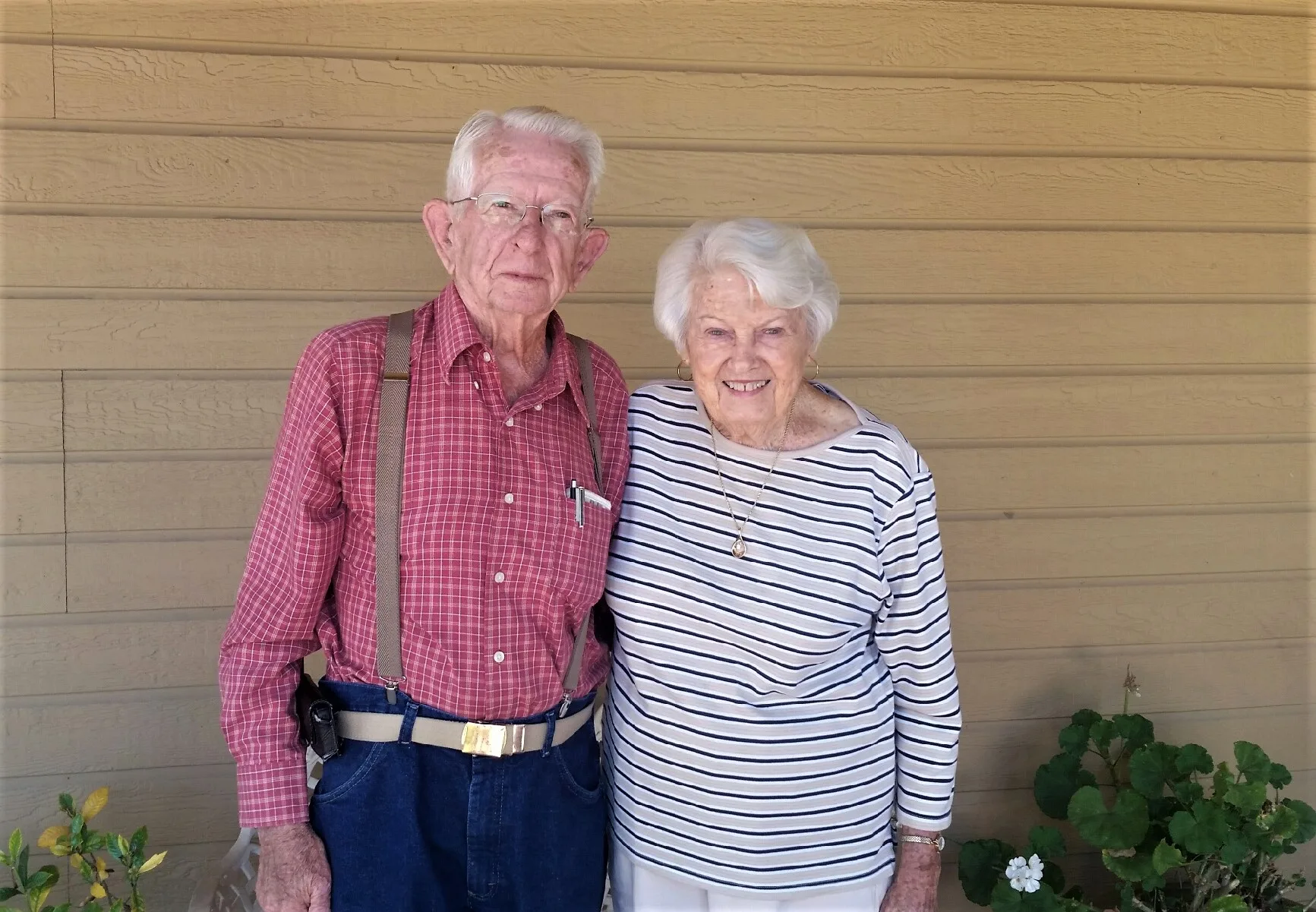 Marvin and Alta, a retired Murrieta Fire Chief and his wife, standing together against a wood-paneled wall