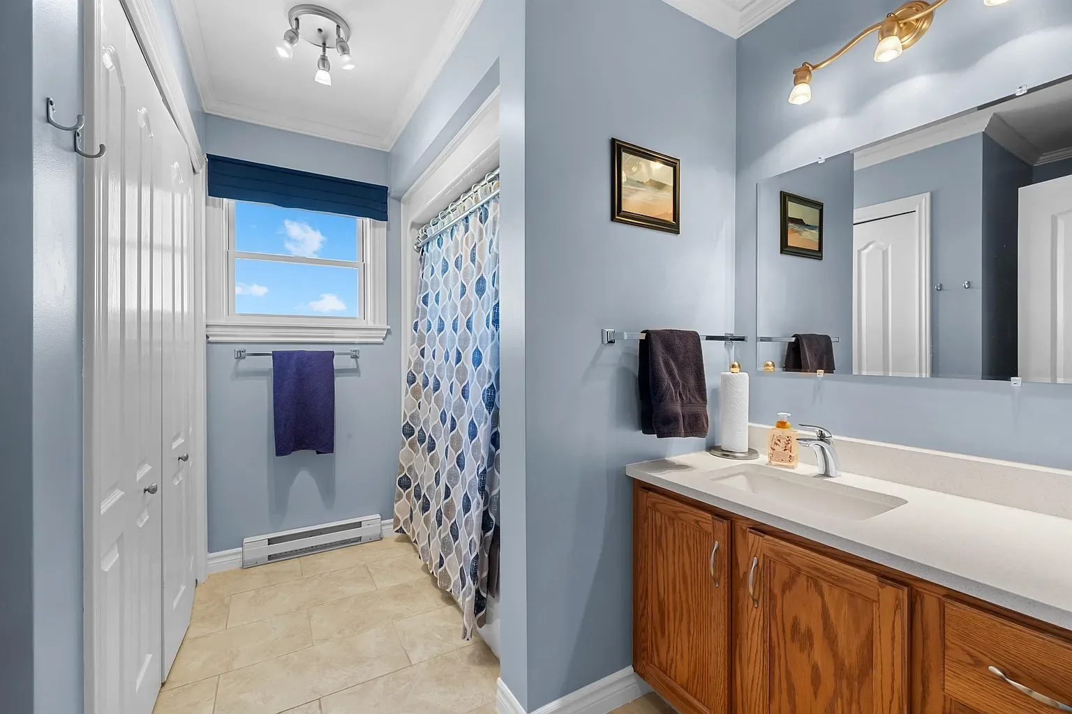 Bathroom with blue walls and oak vanity