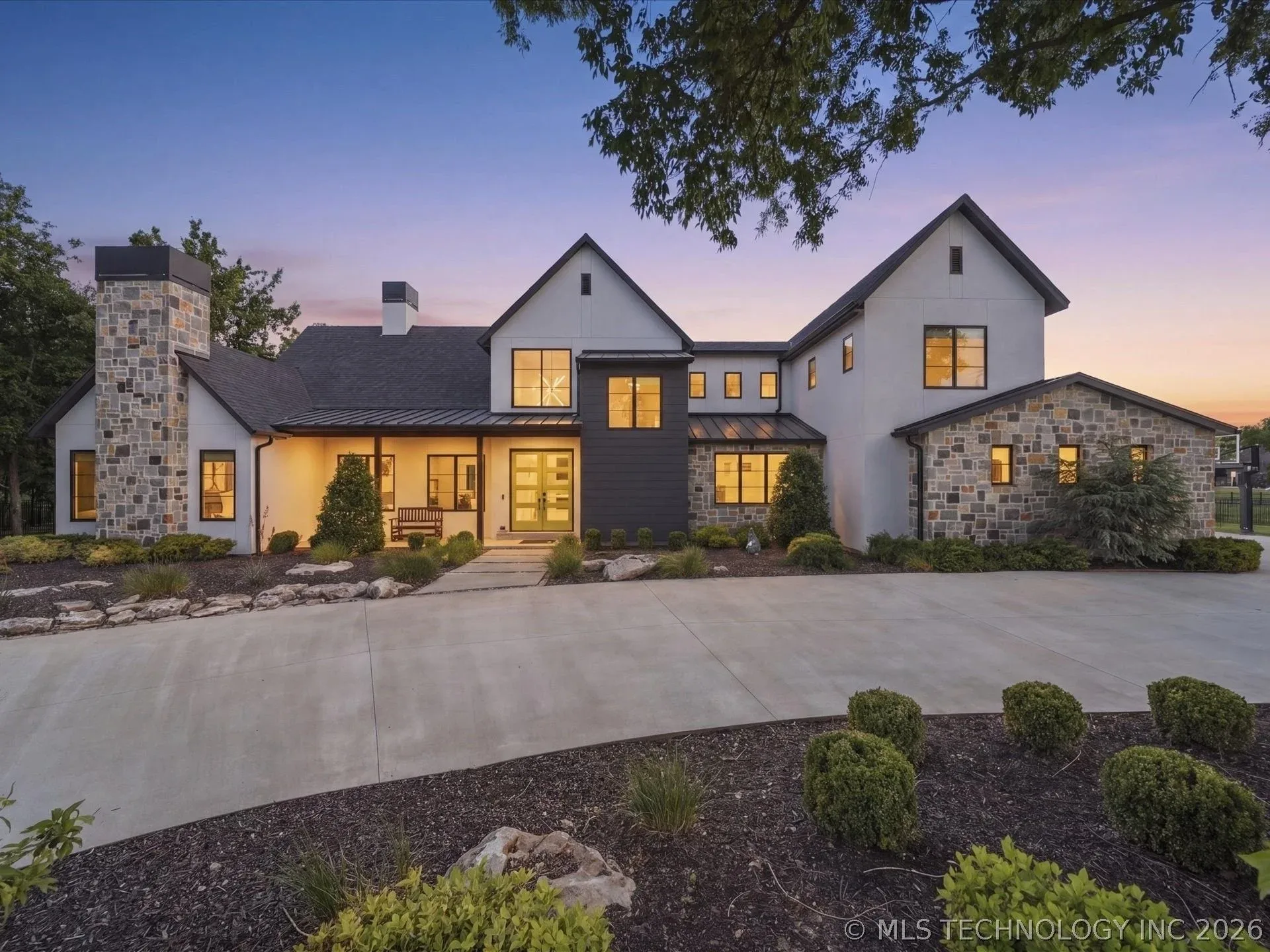 Twilight exterior view of 17120 E Sunset Ridge, a luxury home in Owasso, Oklahoma