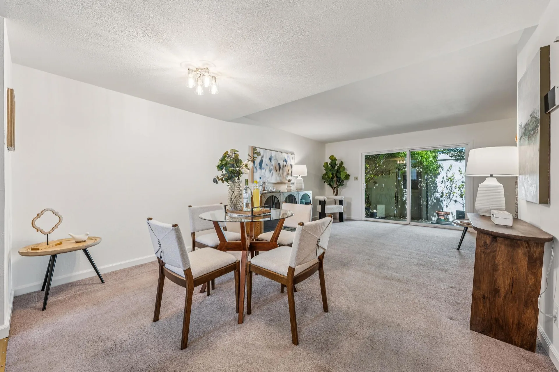 Open-plan dining and living area with carpeted floors and white walls