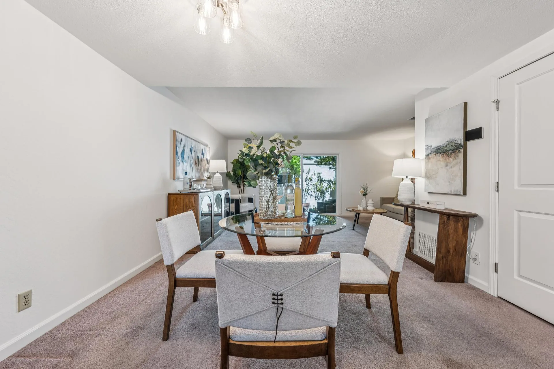 Open-concept dining area flowing into the living room with overhead lighting