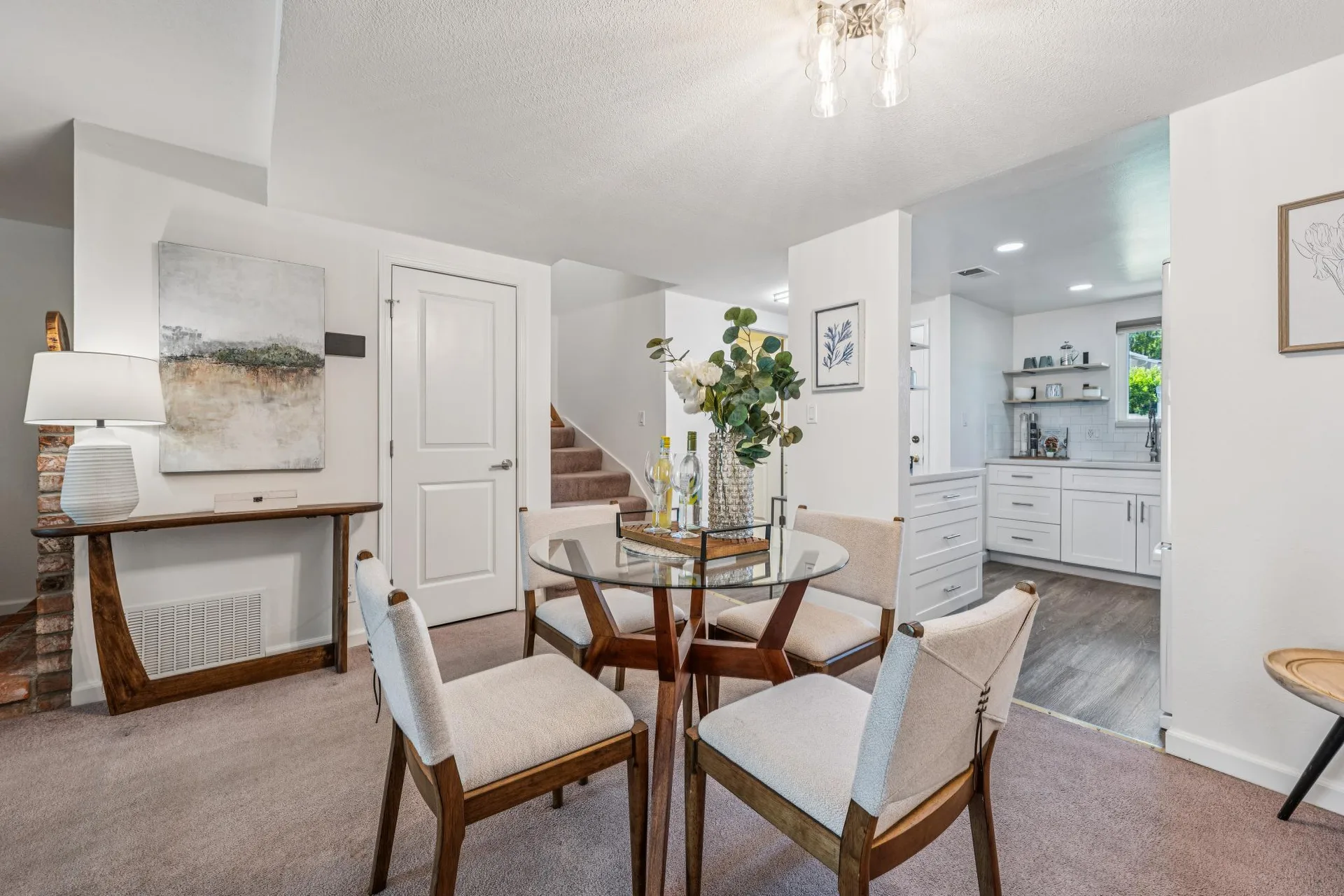 Dining area with glass-top table and partial view of the updated kitchen