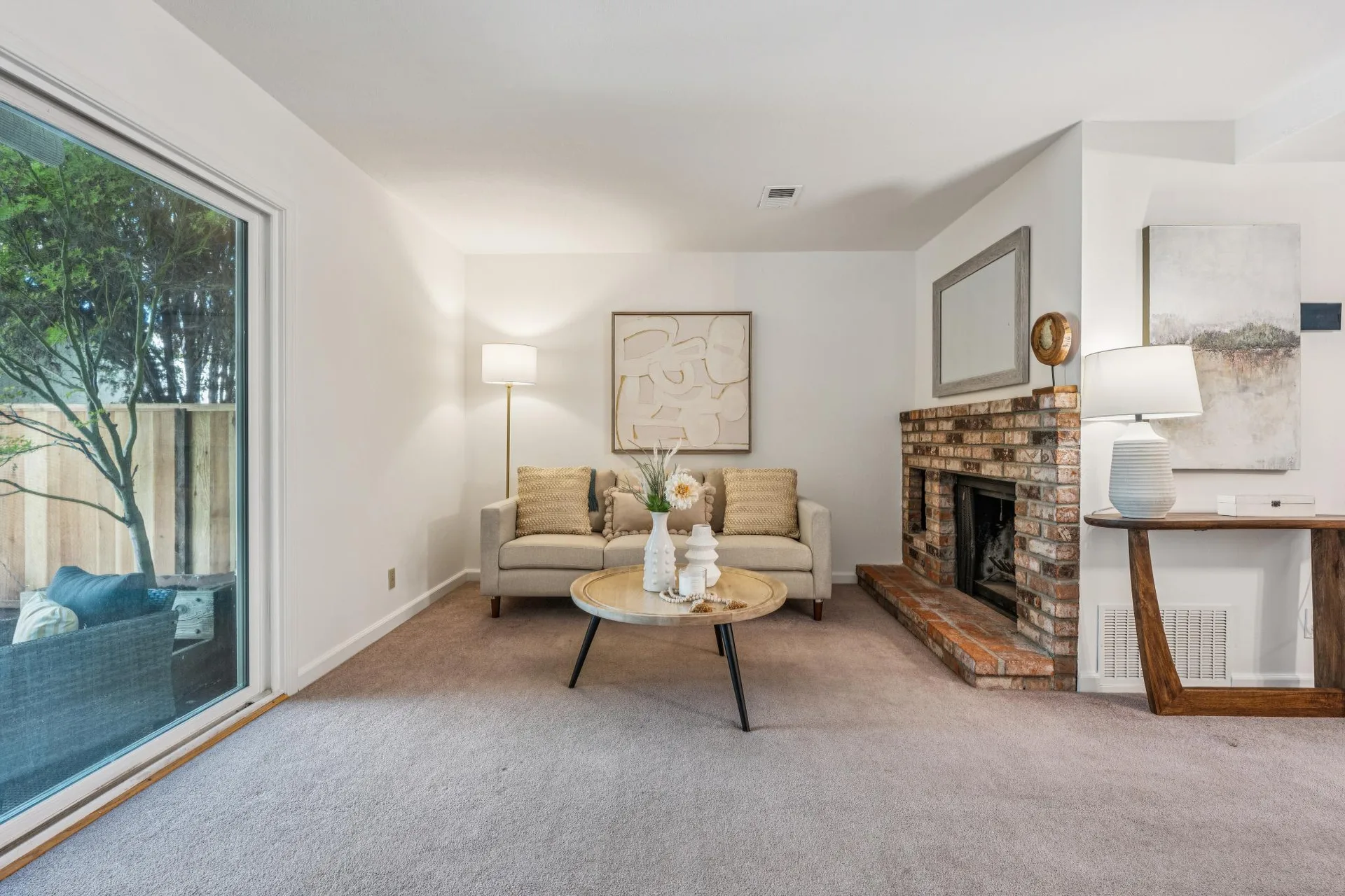 Living room featuring a brick fireplace with mantel mirror and neutral wall paint