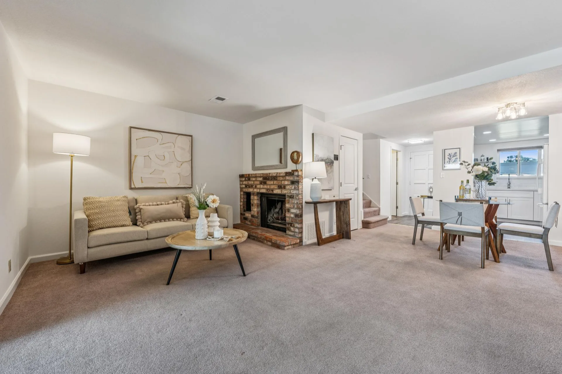 Open living and dining area with brick fireplace and dining table