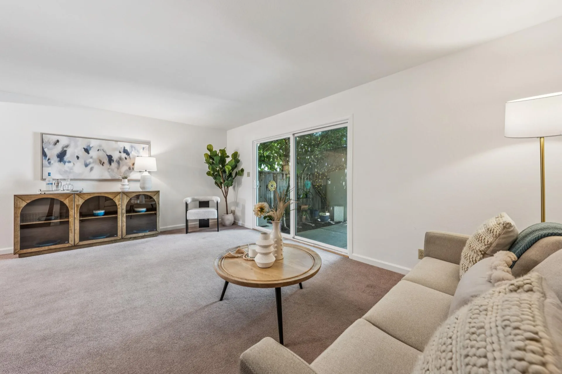 Living room facing sliding patio doors with soft daylight streaming in